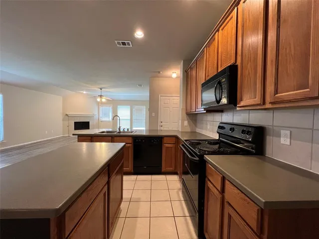 a kitchen with stainless steel appliances granite countertop a sink a stove microwave and cabinets