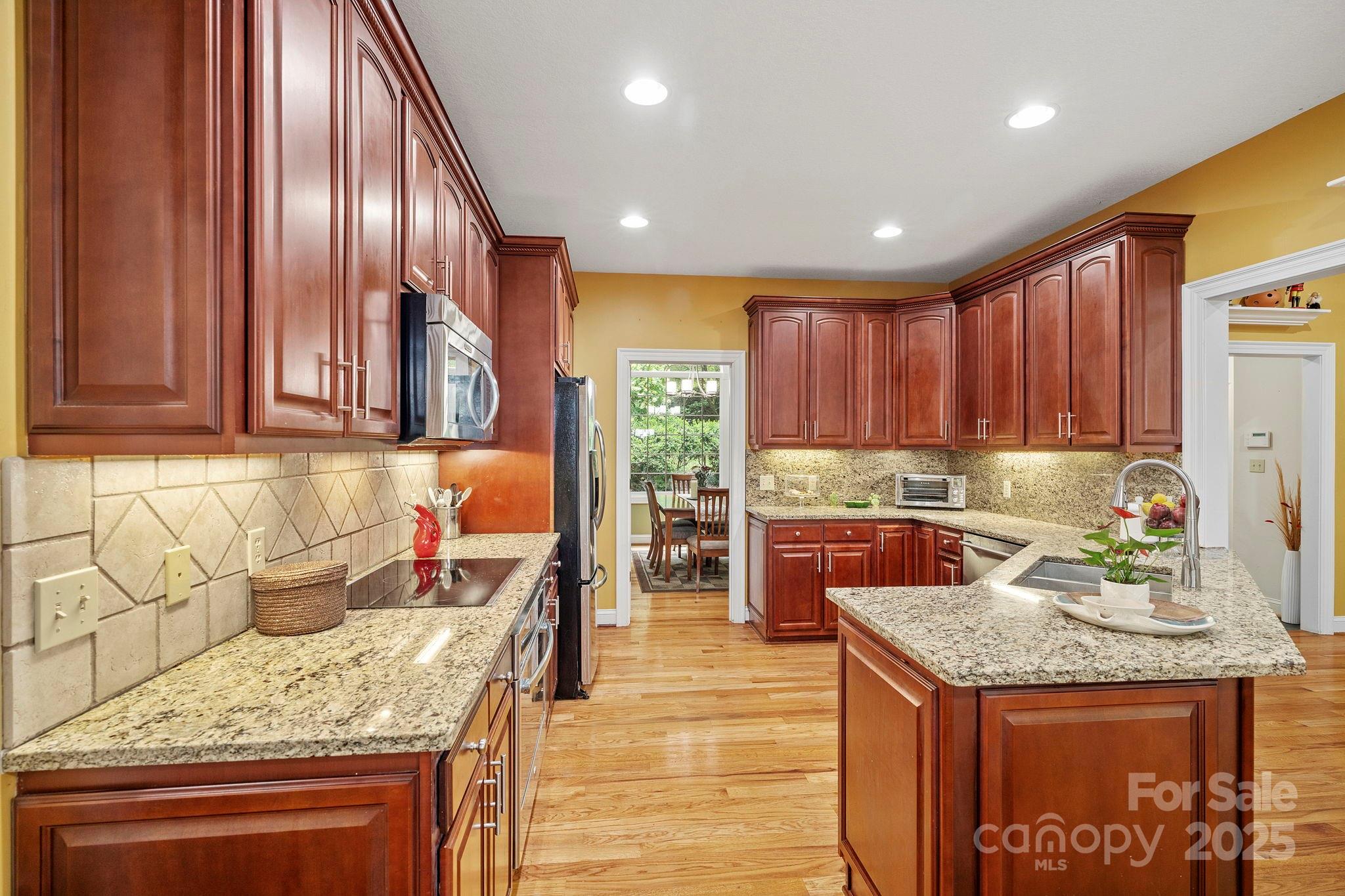 458 Blue Mist Way Arden, NC 28704 - Photo 12 of 47 a kitchen with stainless steel appliances granite countertop wooden cabinets a stove and a sink