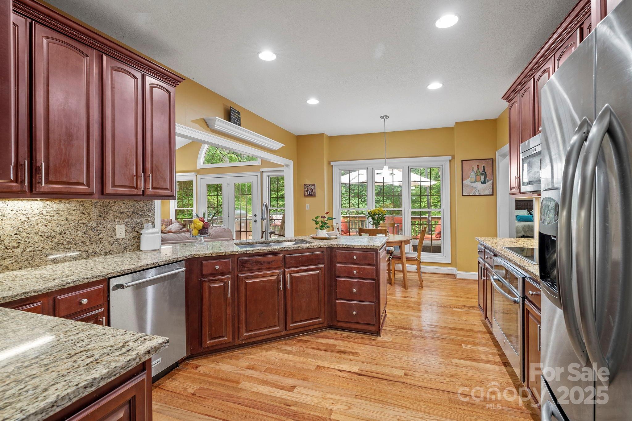 458 Blue Mist Way Arden, NC 28704 - Photo 13 of 47 a large kitchen with kitchen island granite countertop a large window and stainless steel appliances