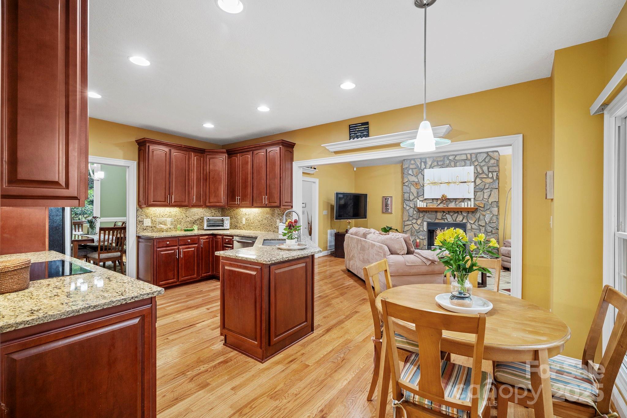 458 Blue Mist Way Arden, NC 28704 - Photo 15 of 47 a kitchen with stainless steel appliances kitchen island granite countertop a table chairs and a refrigerator