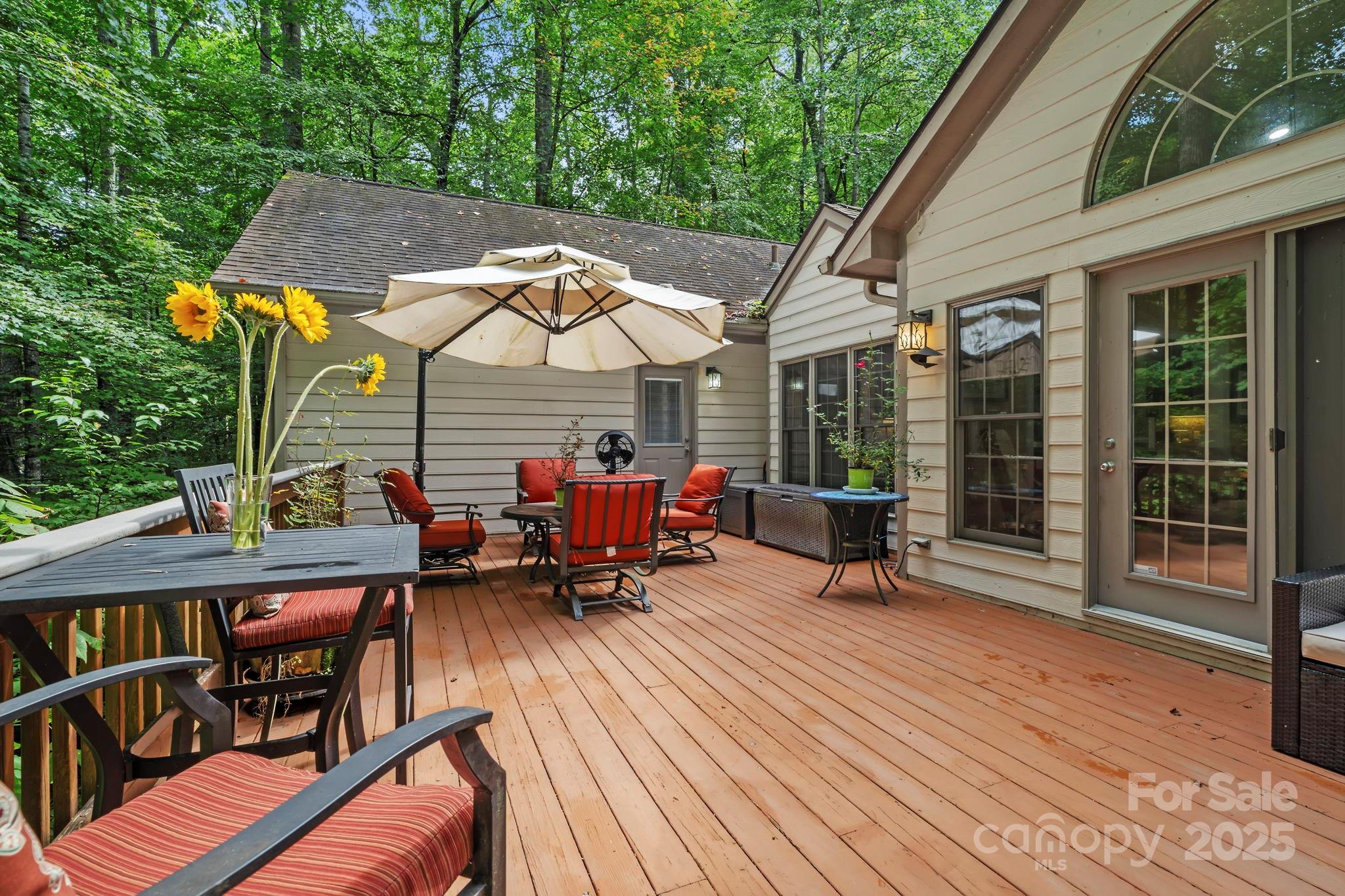 458 Blue Mist Way Arden, NC 28704 - Photo 36 of 47 a view of a roof deck with table and chairs under an umbrella with wooden floor