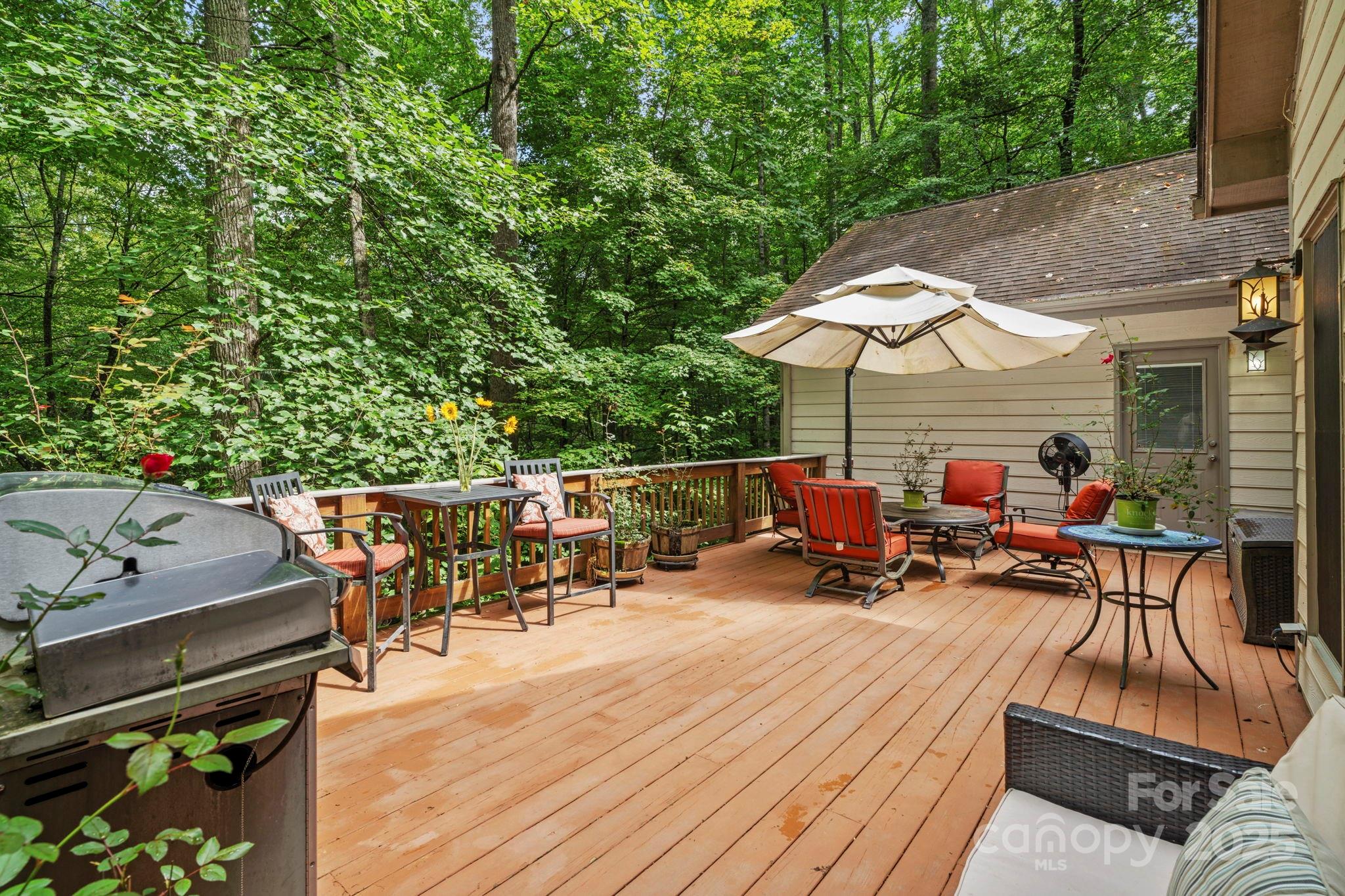 458 Blue Mist Way Arden, NC 28704 - Photo 38 of 47 a view of a roof deck with table and chairs under an umbrella with wooden floor