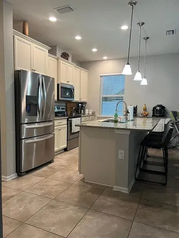 a living room with furniture and view of kitchen