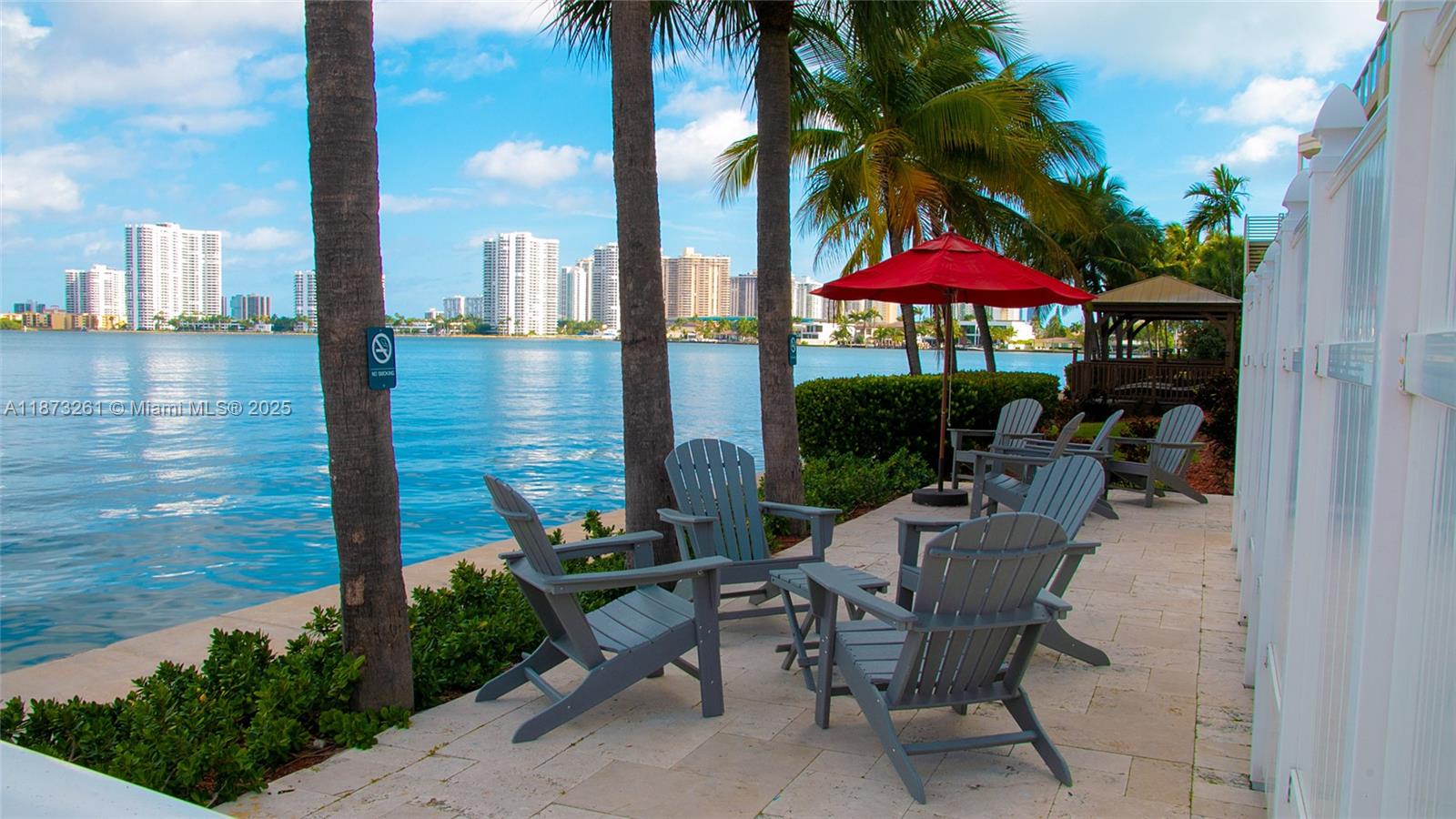 18100 North Bay Road, Unit 509 Sunny Isles Beach, FL 33160 - Photo 13 of 14 a view of a patio with table and chairs under an umbrella with potted plants