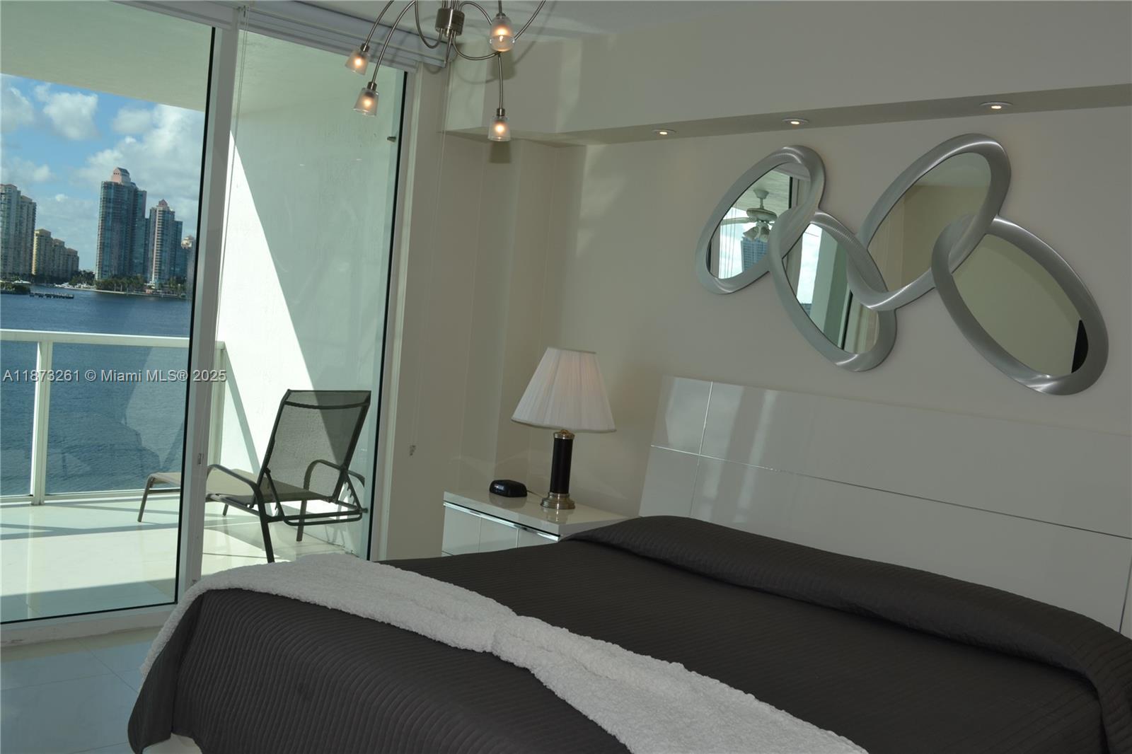 18100 North Bay Road, Unit 509 Sunny Isles Beach, FL 33160 - Photo 14 of 14 a bedroom with a bed and a chandelier