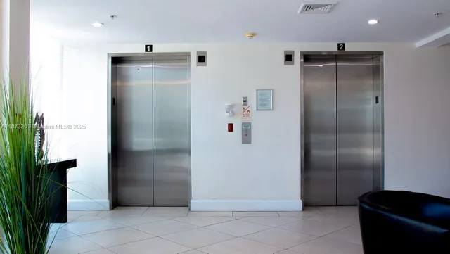 a view of a refrigerator in kitchen and an empty room