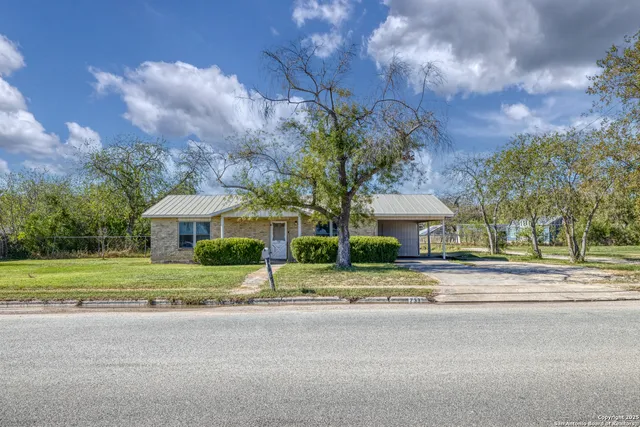 a yellow house with trees in front of it