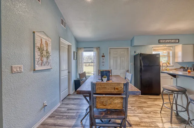 a living room with furniture and a refrigerator