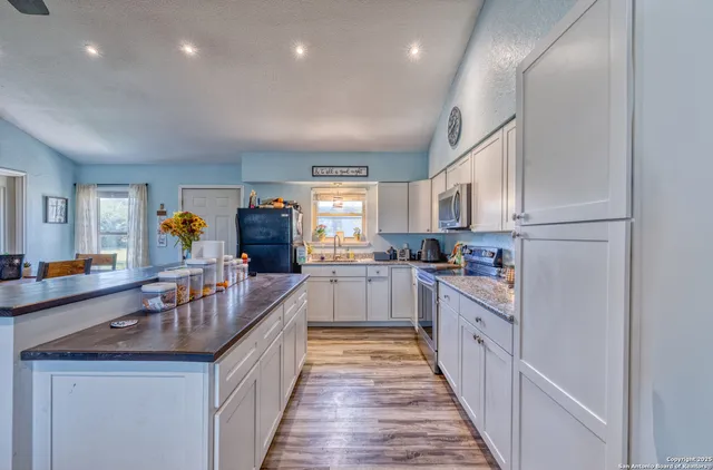 a kitchen with counter top space a sink appliances and cabinets