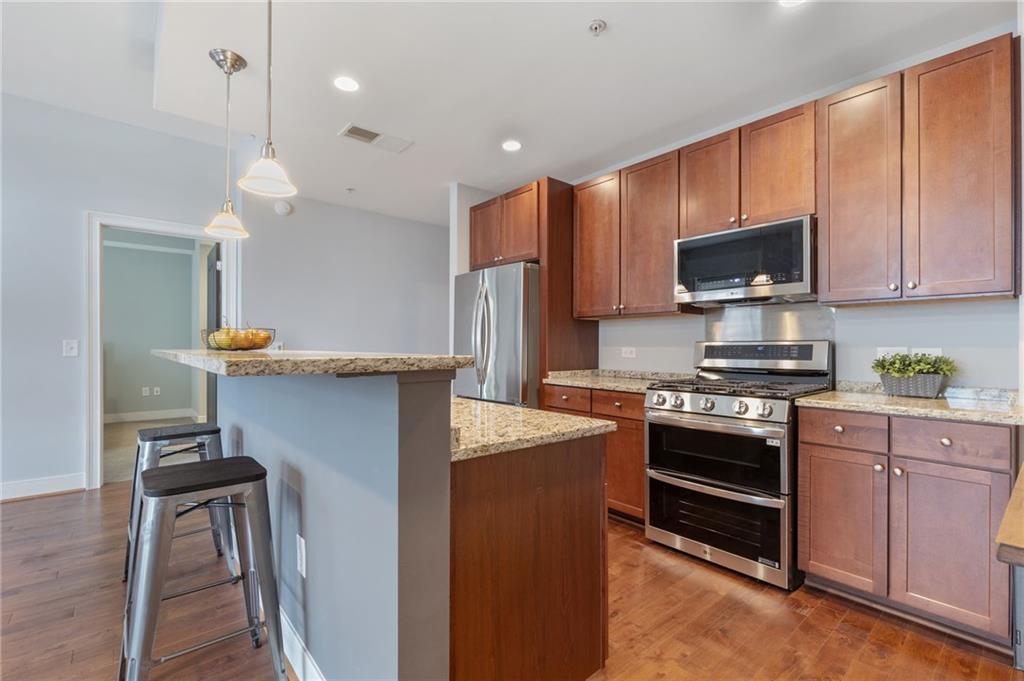 201 West Ponce De Leon Avenue, Unit 35 Decatur, GA 30030 - Photo 6 of 42 a kitchen with stainless steel appliances granite countertop a stove refrigerator sink and microwave