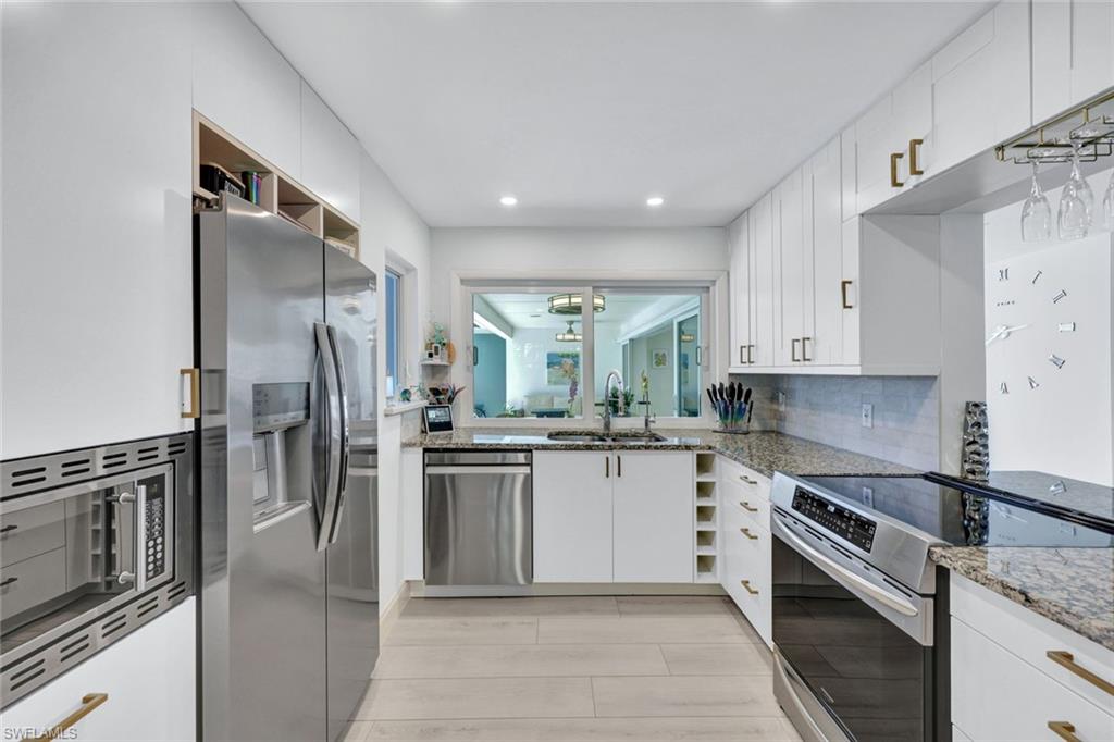 1550 Sandpiper Street Naples, FL 34102 - Photo 8 of 34 a kitchen with stainless steel appliances granite countertop a refrigerator a stove and a sink