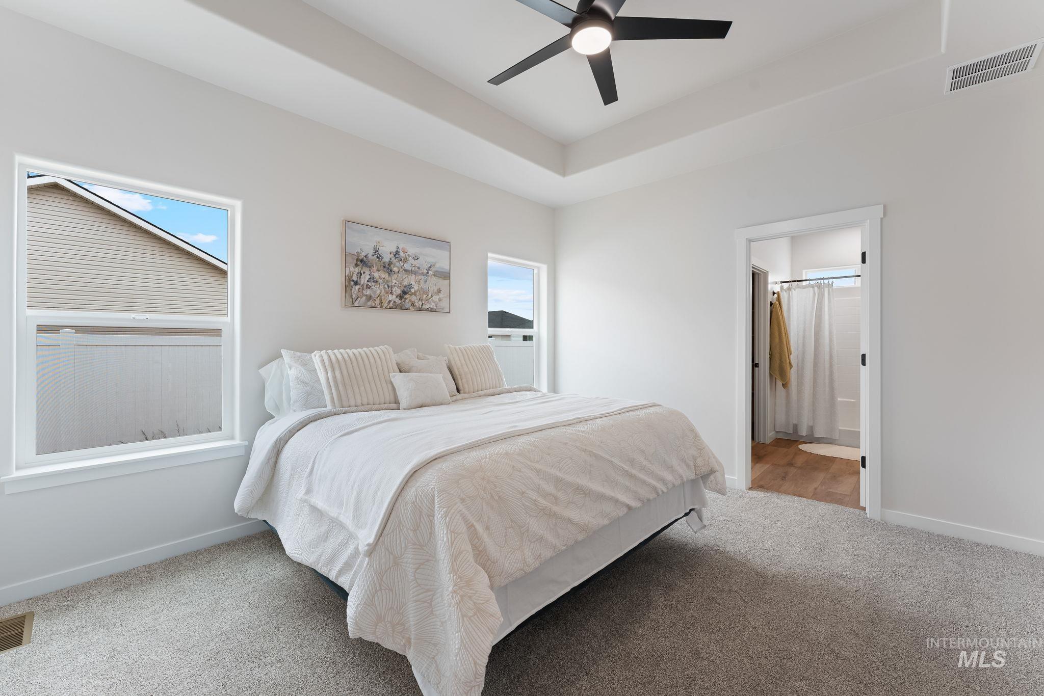 2220 Great Basin Way Burley, ID 83318 - Photo 19 of 39 Bedroom featuring carpet, a ceiling fan, connected bathroom, and a raised ceiling