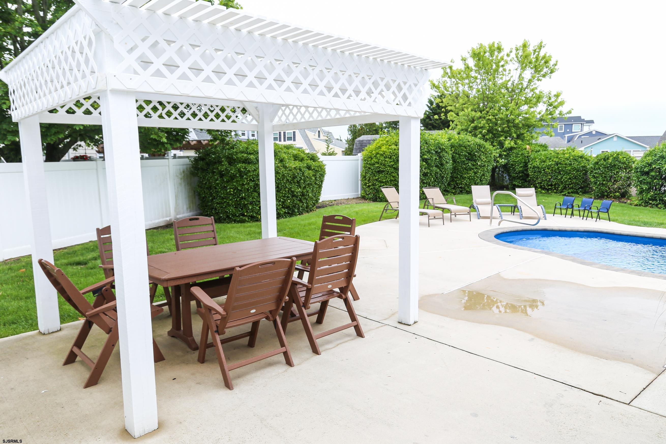 8 44th Cove Brigantine, NJ 08203 - Photo 37 of 57 a view of a patio with a table chairs and backyard