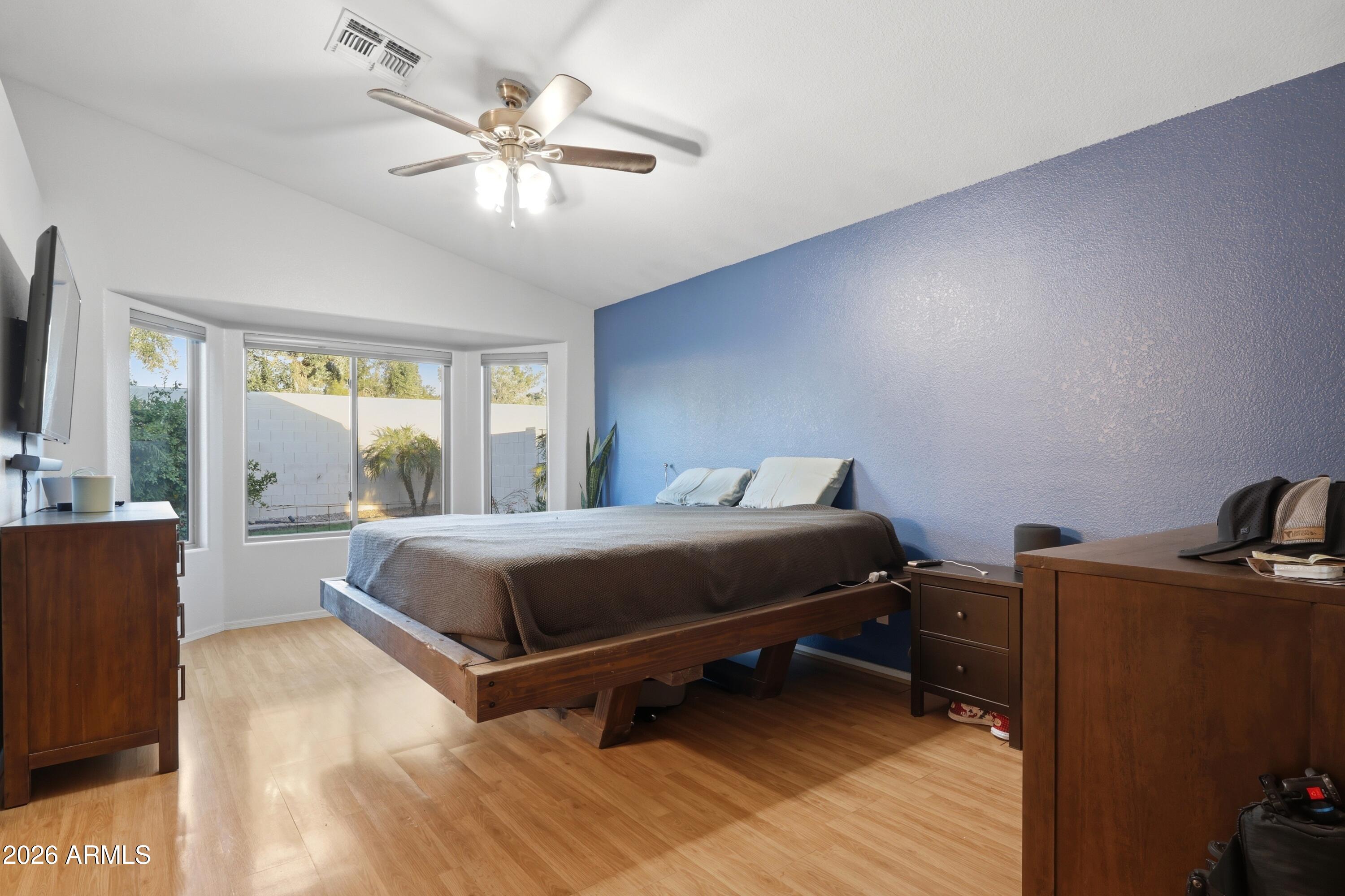 661 North Joshua Tree Lane Gilbert, AZ 85234 - Photo 13 of 47 a bedroom with a bed and a large window with wooden floor