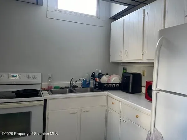 a kitchen with sink cabinets and appliances