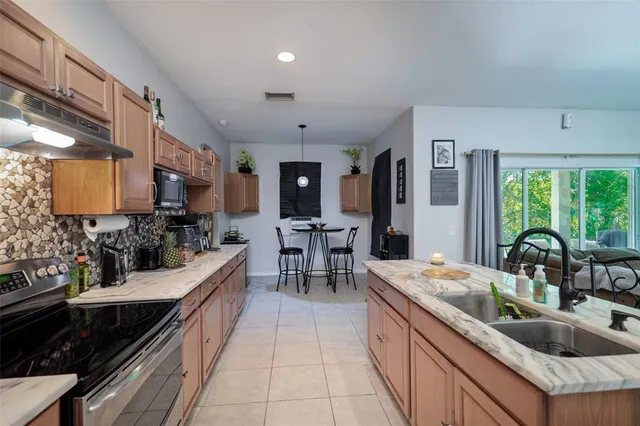 a large kitchen with a large counter top furniture a sink a stove and a window