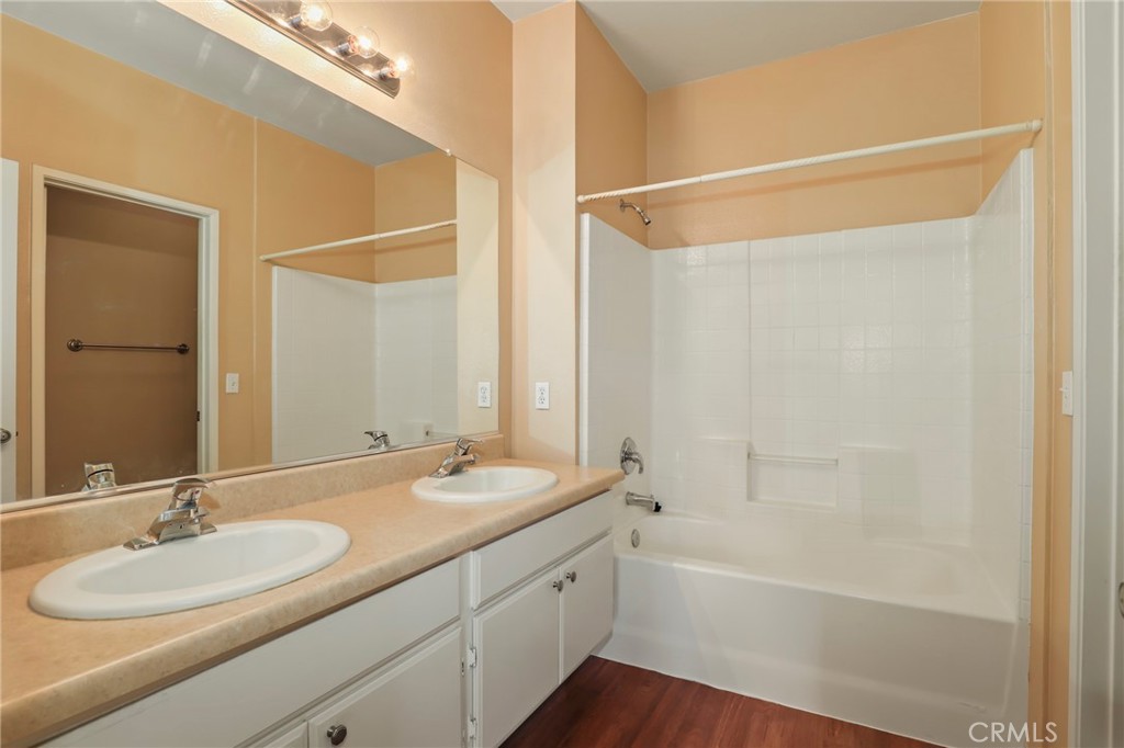 20000 Plum Canyon Road, Unit 1722 Saugus, CA 91350 - Photo 18 of 30 a bathroom with a granite countertop sink a mirror and a bathtub