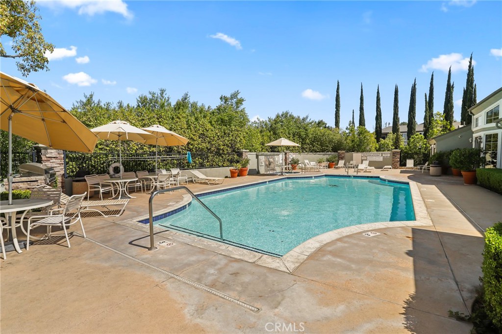 20000 Plum Canyon Road, Unit 1722 Saugus, CA 91350 - Photo 23 of 30 a view of a swimming pool with lawn chairs under an umbrella