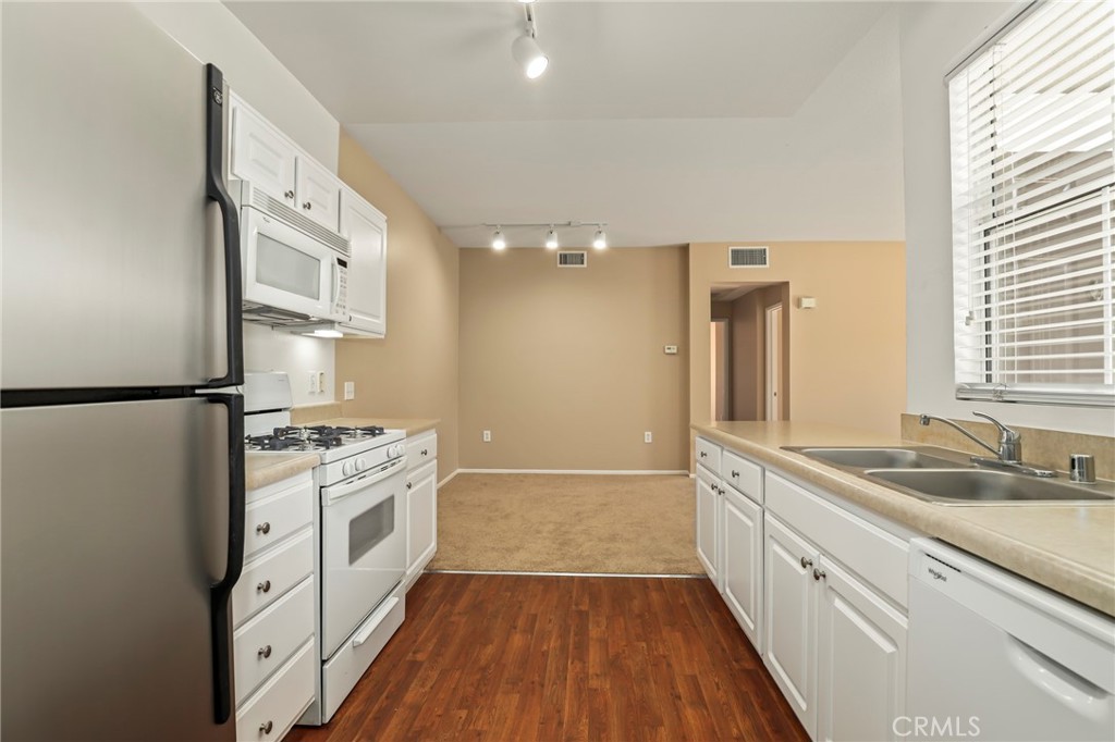 20000 Plum Canyon Road, Unit 1722 Saugus, CA 91350 - Photo 7 of 30 a kitchen with granite countertop a sink stove and refrigerator