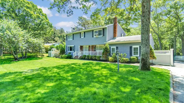 a view of a house with a yard and sitting area
