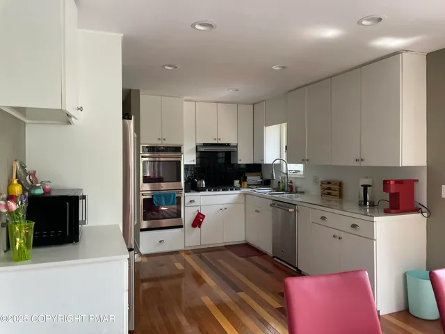 a kitchen with white cabinets and white appliances