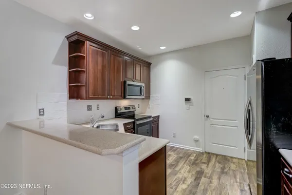 a kitchen with a sink a refrigerator and cabinets