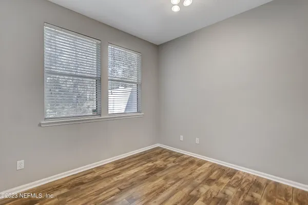 a view of empty room with wooden floor