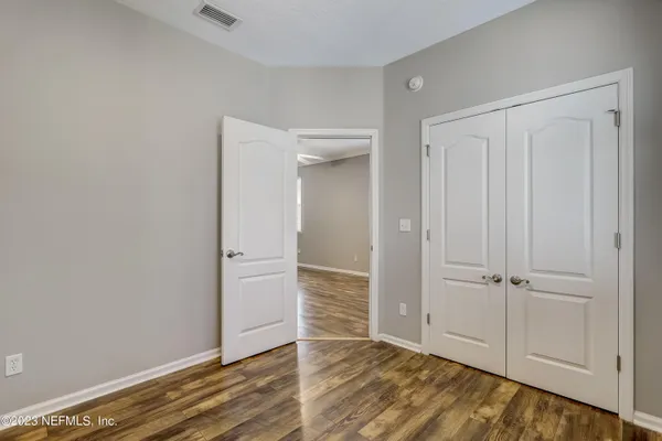 an empty room with wooden floor and closet