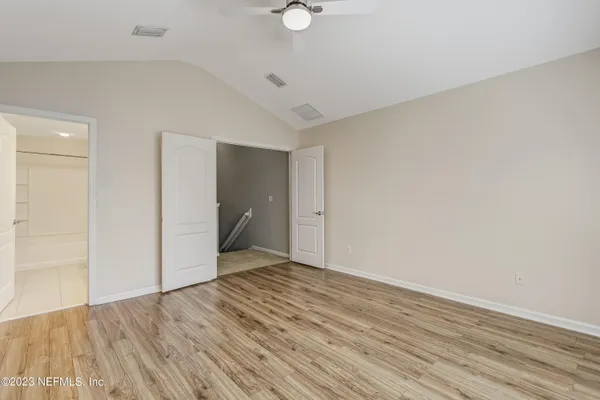 a view of an empty room with wooden floor