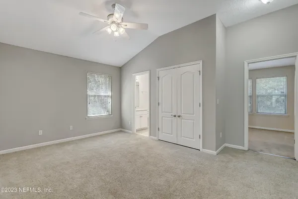 an empty room with windows and fan