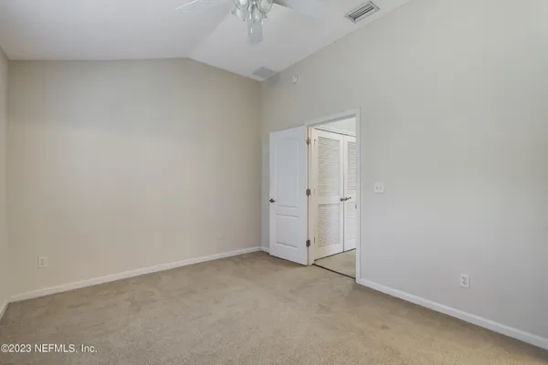an empty room with a ceiling fan and a window