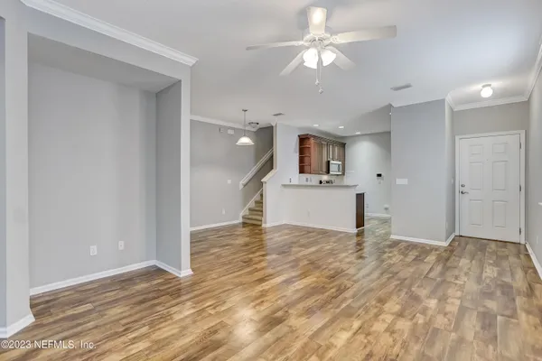 a view of a kitchen with wooden floor and a ceiling fan