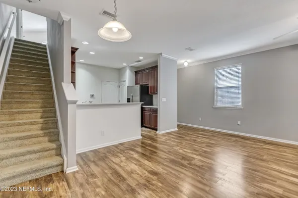 a view of a kitchen with wooden floor and staircase