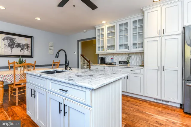 a kitchen with stainless steel appliances granite countertop a sink and cabinets with wooden floor
