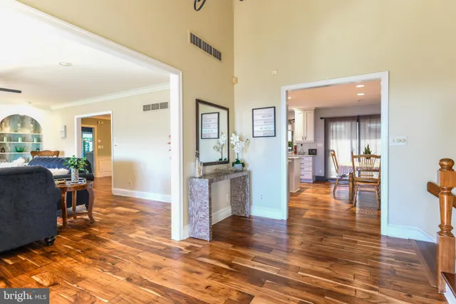 a view of a living room and kitchen with furniture wooden floor and windows