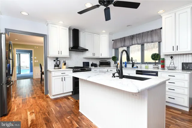 a kitchen with stainless steel appliances kitchen island a sink and a stove top oven