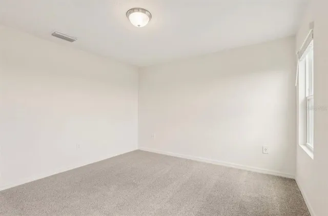 an empty room with windows and closet