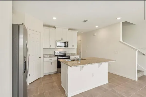 a kitchen with a sink a stove a refrigerator and cabinets