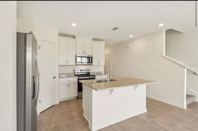 a kitchen with a sink a stove a refrigerator and cabinets