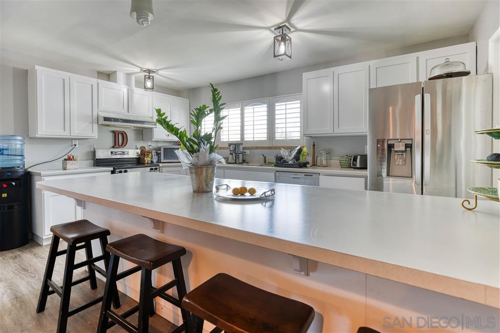1906 Tavern Road Alpine, CA 91901 - Photo 6 of 16 a kitchen with stainless steel appliances granite countertop a sink a stove and a refrigerator with wooden floor