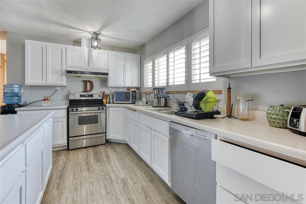 1906 Tavern Road Alpine, CA 91901 - Photo 7 of 16 a kitchen with white cabinets appliances a sink and a window