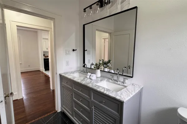 a bathroom with a granite countertop sink and a mirror