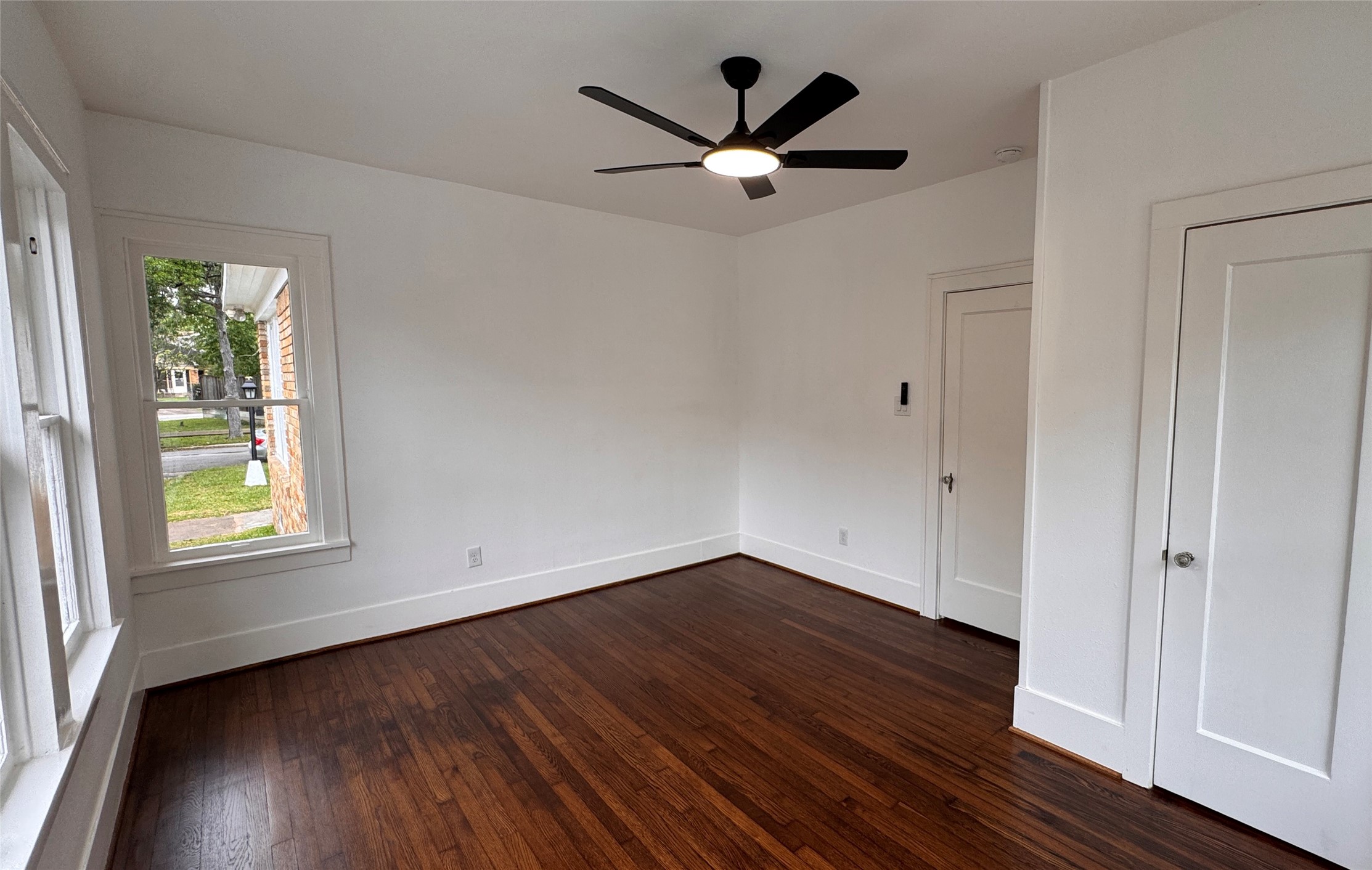 1569 Elliott Street Houston, TX 77023 - Photo 12 of 14 an empty room with wooden floor and windows