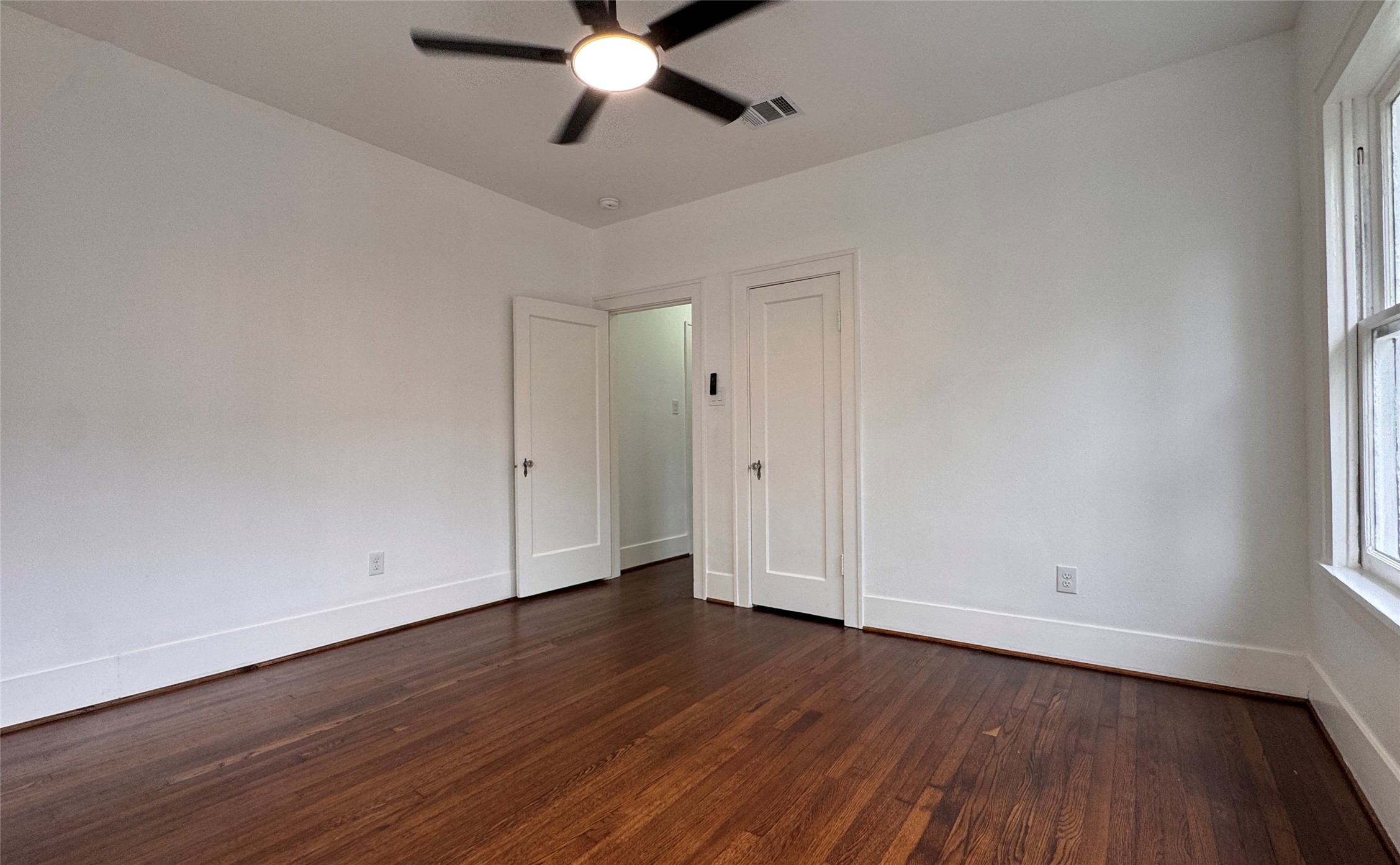 1569 Elliott Street Houston, TX 77023 - Photo 13 of 14 a view of an empty room with wooden floor and a window