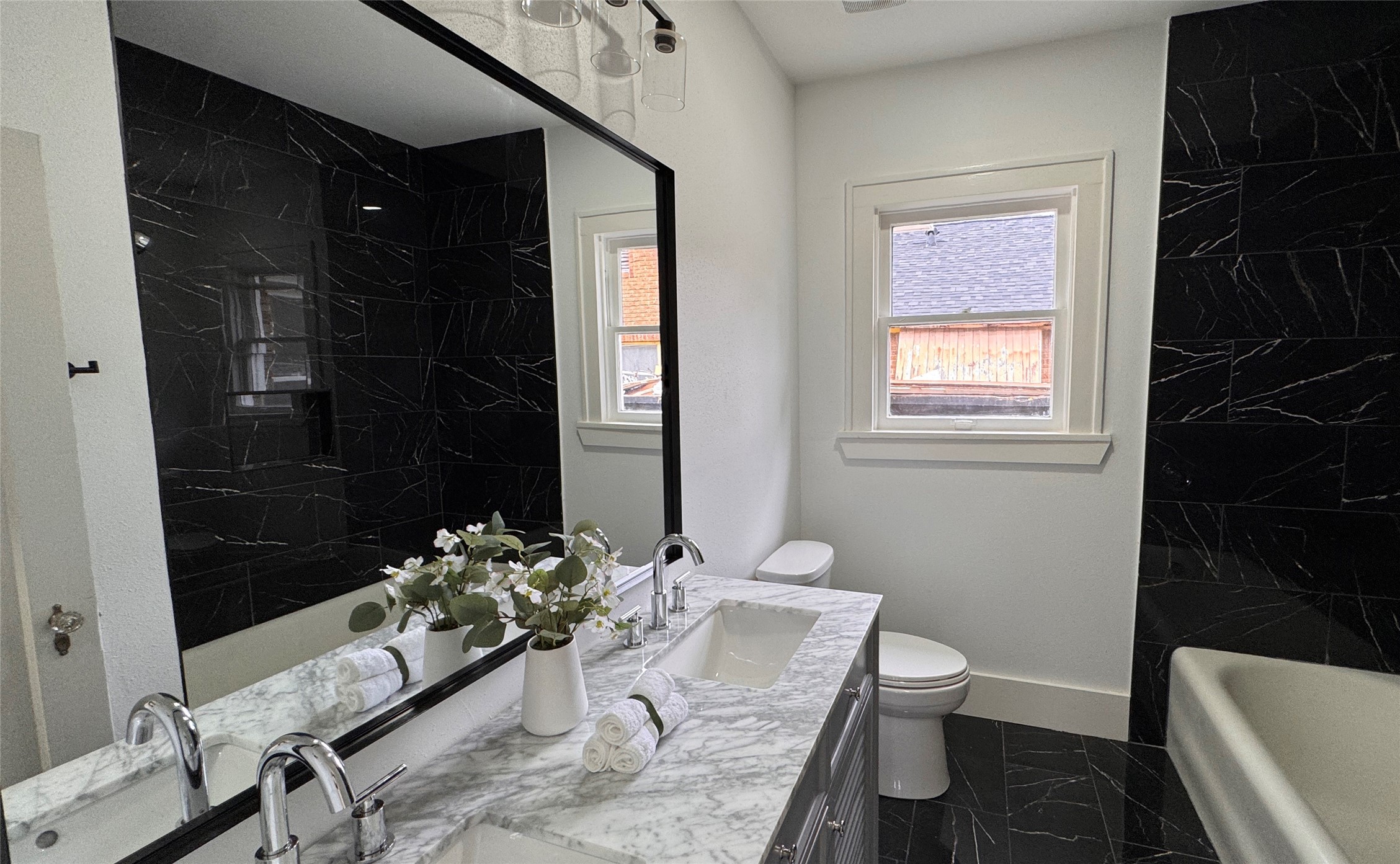 1569 Elliott Street Houston, TX 77023 - Photo 9 of 14 a bathroom with a granite countertop sink a toilet and shower