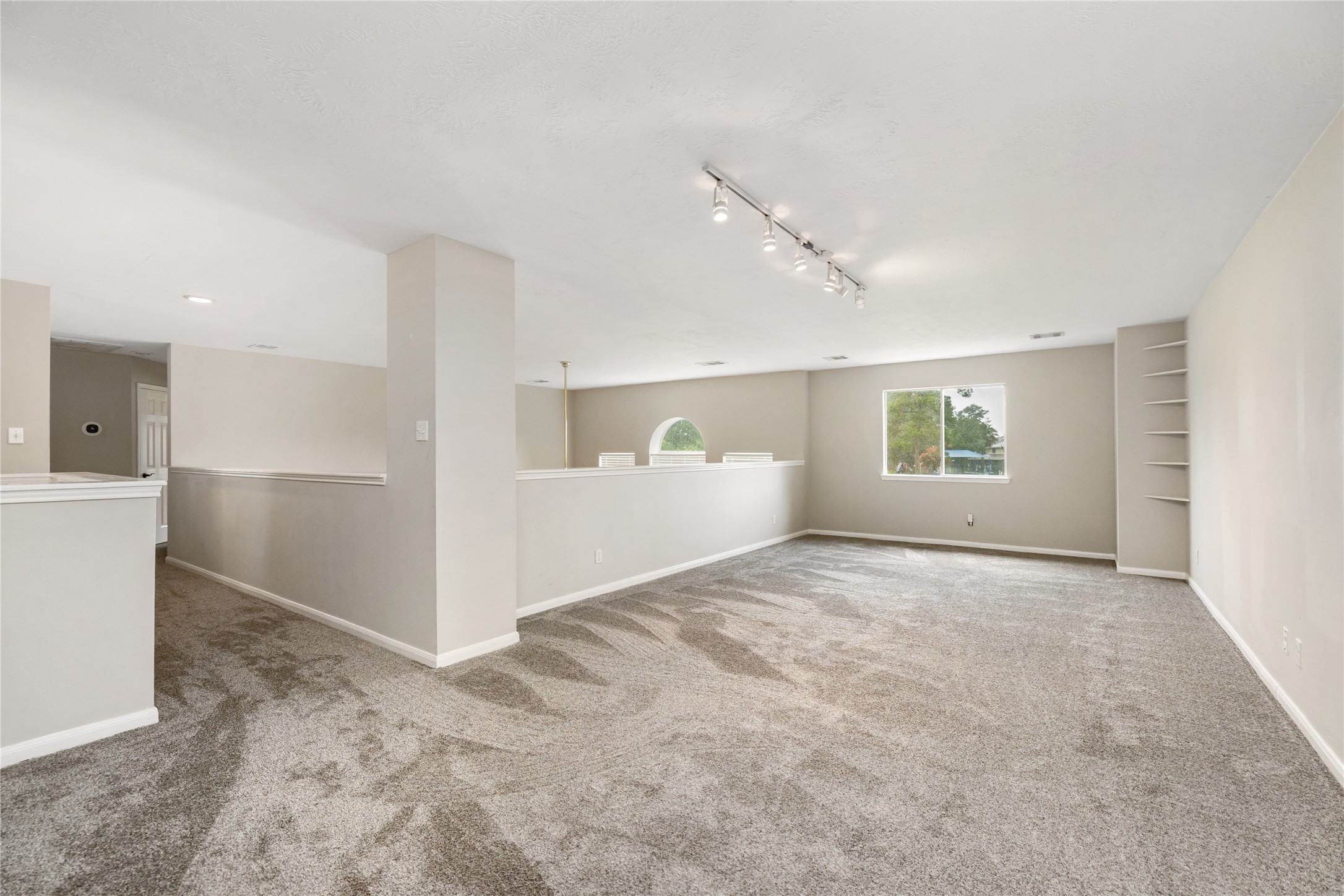 20735 Deauville Drive Spring, TX 77388 - Photo 16 of 33 The massive upstairs game room offers versatile space filled with natural light from large windows—perfect for play, relaxation, or a custom home gym.