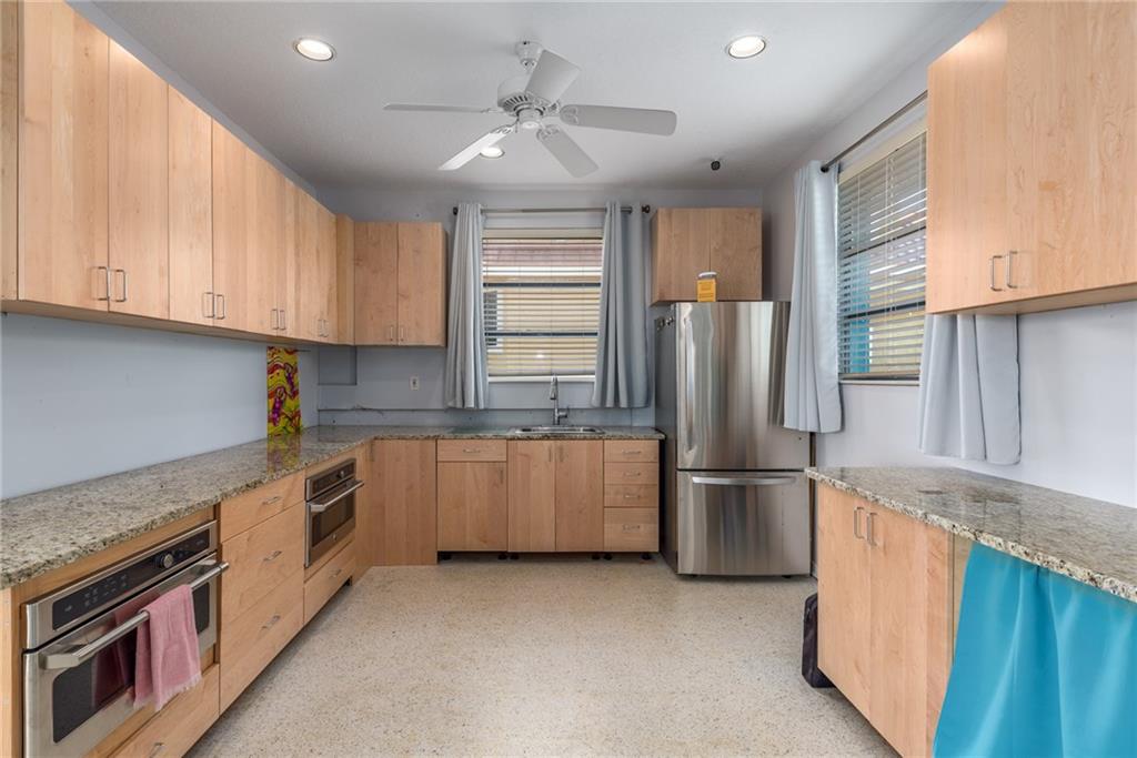 5111 Southeast Post Terrace Stuart, FL 34997 - Photo 30 of 34 a kitchen with stainless steel appliances granite countertop a refrigerator a sink and a stove