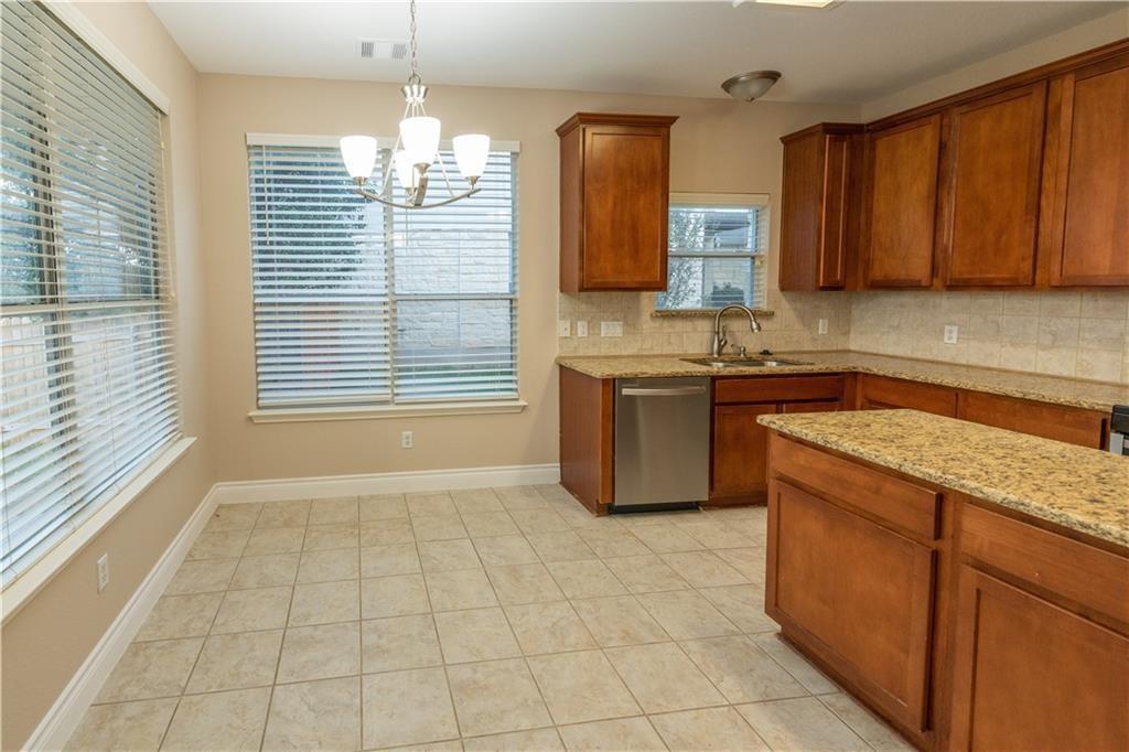 12017 Springs Head Loop Austin, TX 78717 - Photo 8 of 25 A well-appointed kitchen and dining area features granite counters and tile flooring.