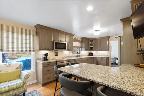 a kitchen with stainless steel appliances granite countertop a sink stove and refrigerator