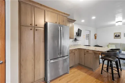 a kitchen with a refrigerator a sink and chairs